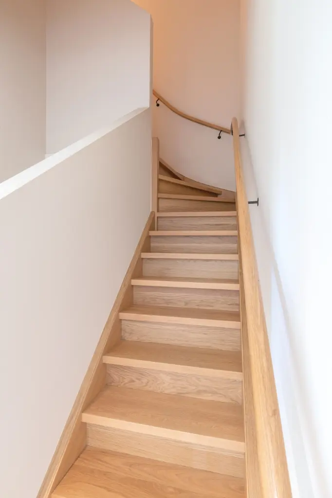 Gesloten, eiken trap tussen muren